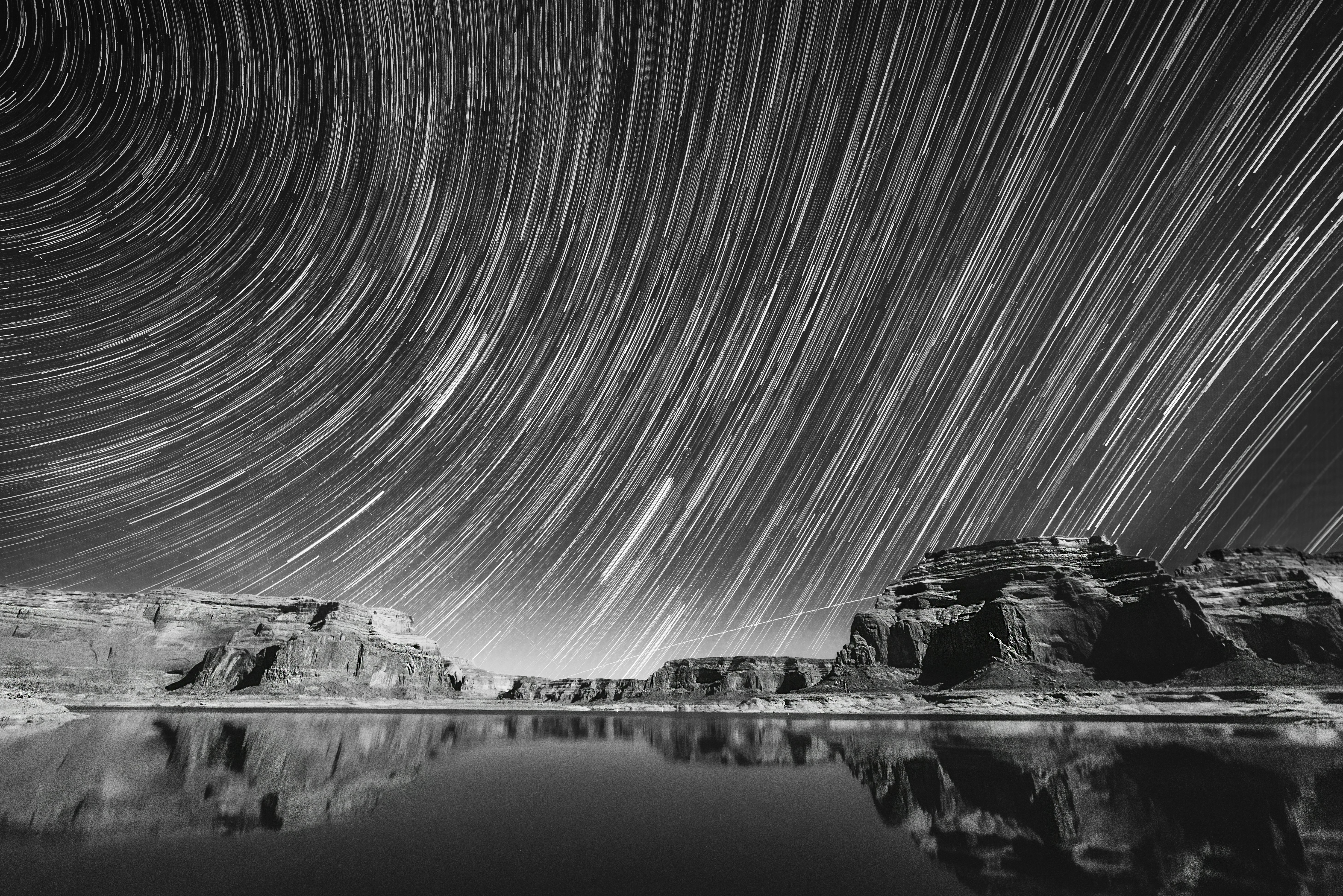 grayscale photography of calm body of water under sky